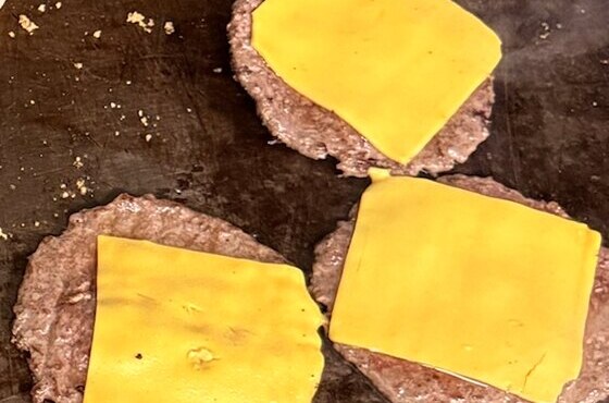 Three cheeseburger patties on the Burger Cart griddle