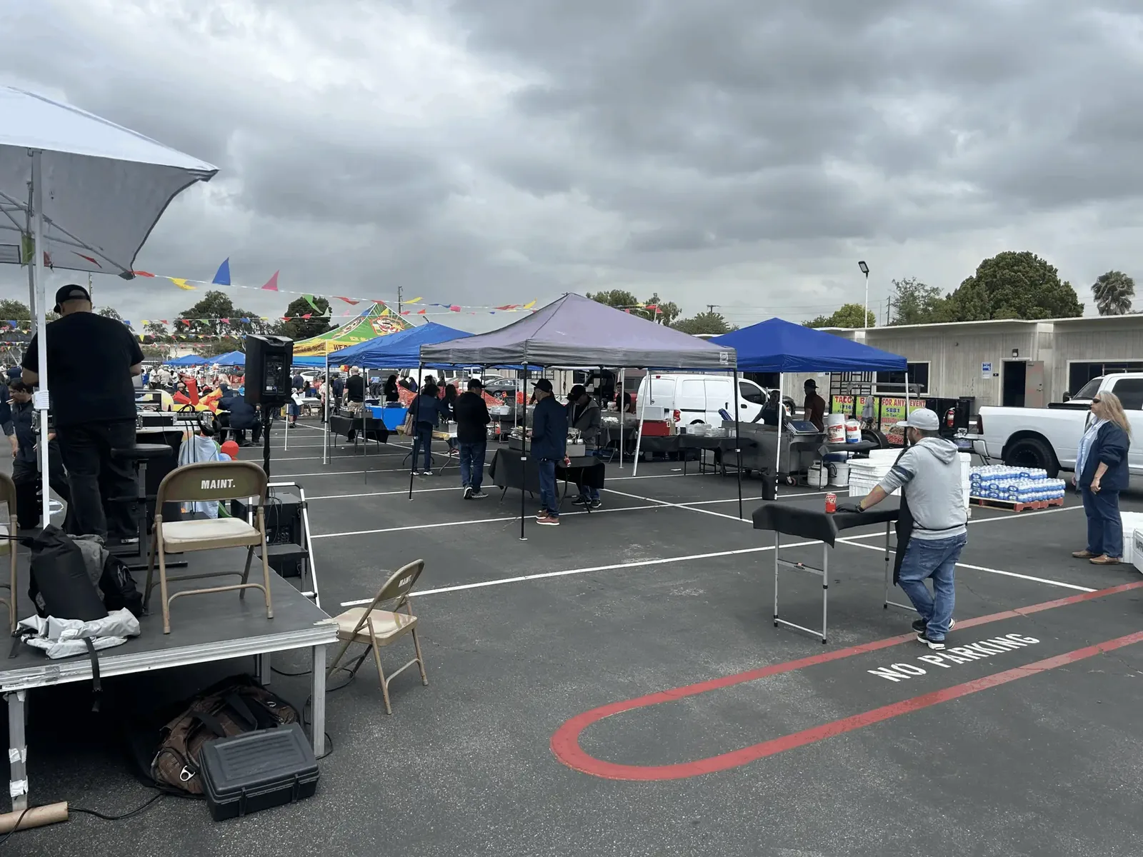 A large outdoor event with the full catering setup under canopies